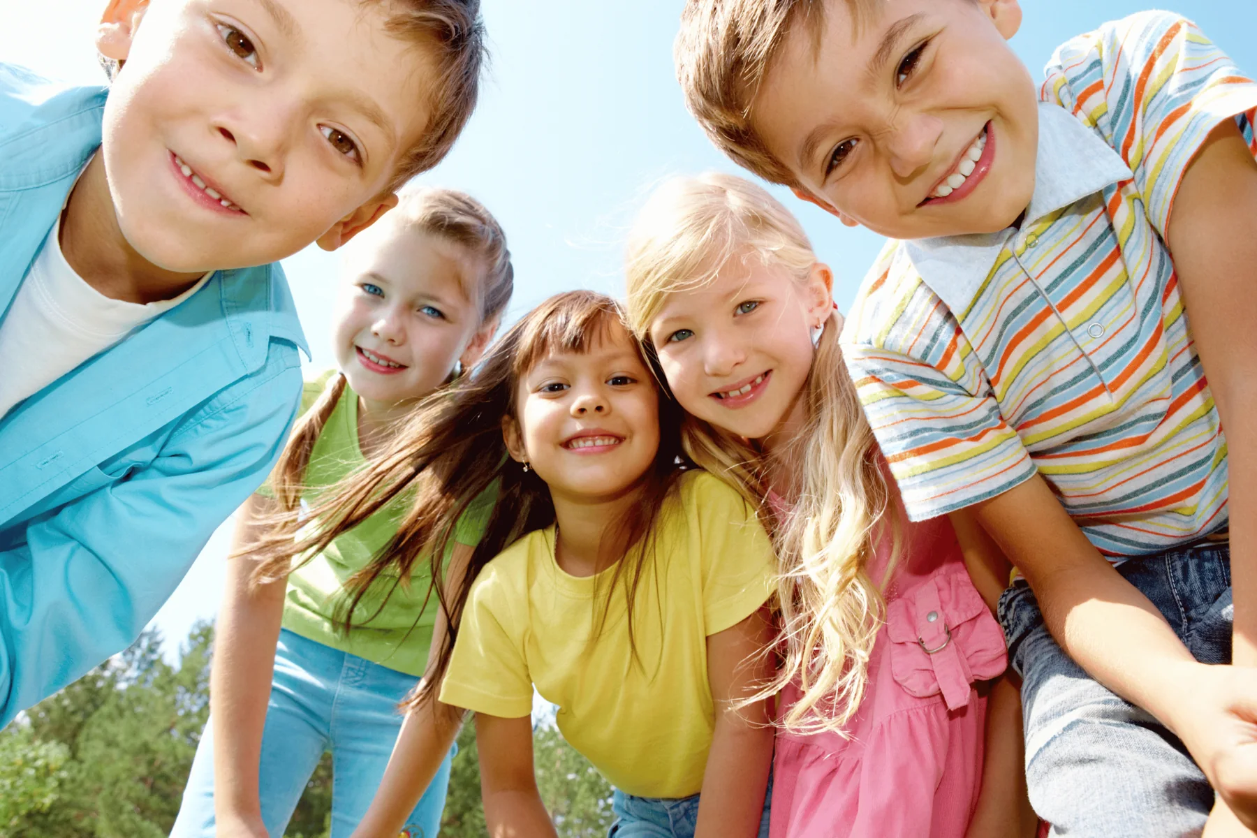 Cinq enfants sourient ensemble